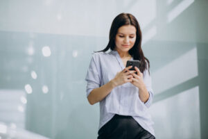 mulher de negocios jovem usando o telefone no escritorio_1303 19788