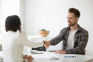 smiling millennial partners handshaking office thanking successful teamwork_1163 4614